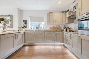 L-shaped kitchen with beige shaker cabinets
