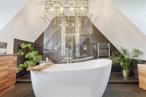 Loft bathroom with freestanding bath and glass shower