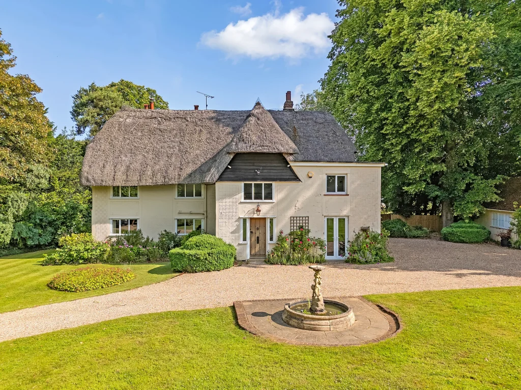 Thatched cottage with a fountain in the front garden
